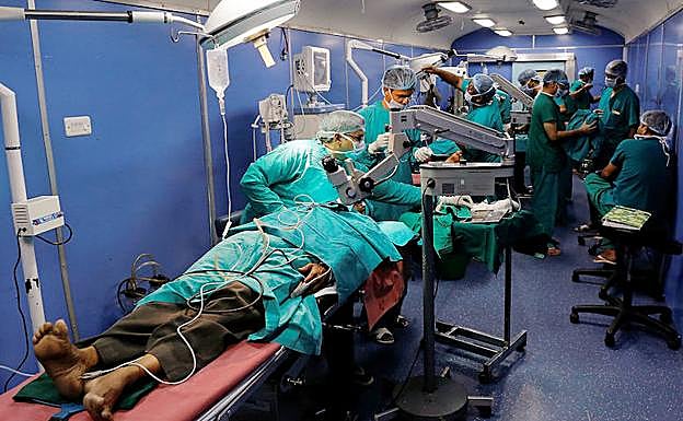 Los cirujanos operan a varios pacientes a la vez en el quirófano instalado en uno de los vagones del tren hospital.