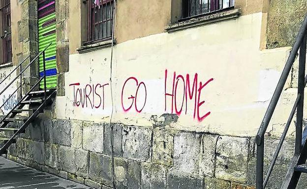 Una de las pintadas aparecidas ayer en Bilbao invita a los turistas a marcharse a su casa.