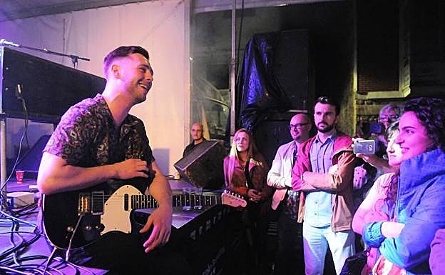 Laurence sentado en el escenario, ante el público arrobado.