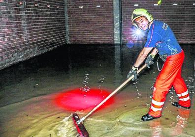 Imagen secundaria 1 - 1. La calle Landako de Amurrio se inundó en unos minutos. 2. Un bombero trabaja en una lonja anegada en Amurrio. 3. El agua baja por Llodio.