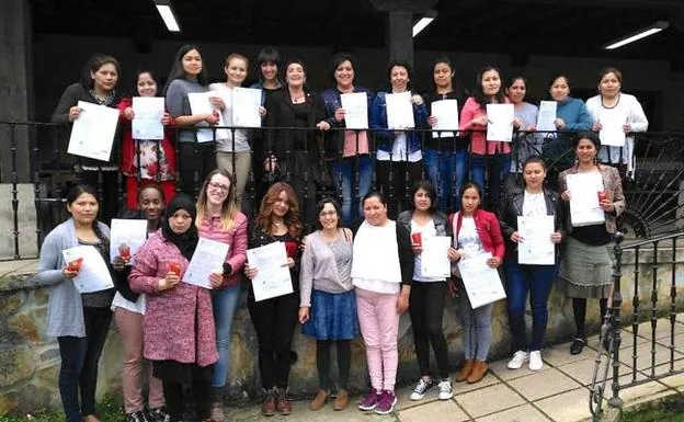 La veintena de mujeres muestran los diplomas conseguidos tras su formación. 