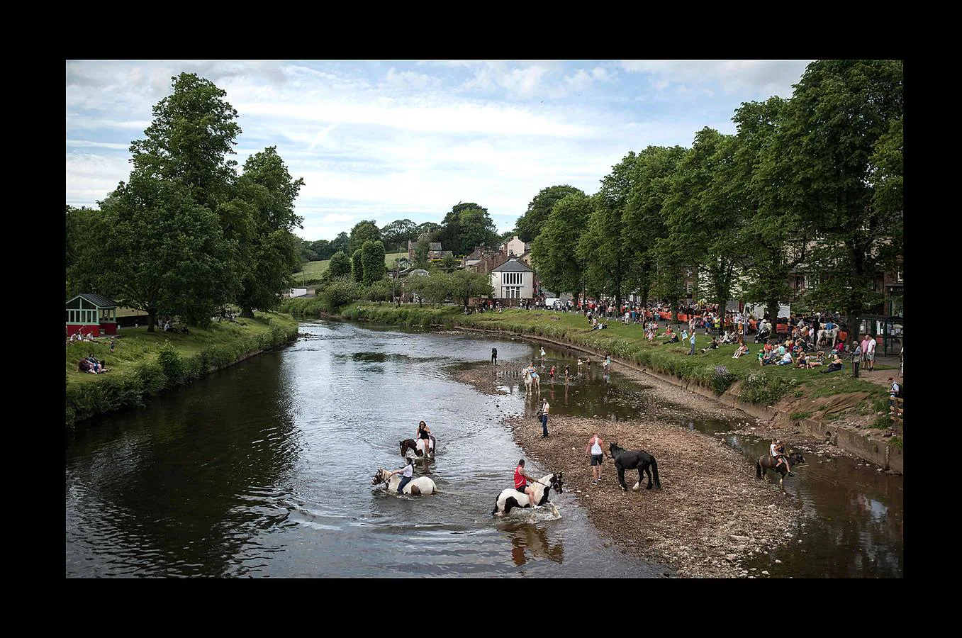 Alrededor de 10.000 personas se han reunido estos días en la localidad de Appleby, en Cumbria, uno de los condados del Reino Unido, para celebrar la feria del caballo. El evento, que según parece data de 1775, es uno de los encuentros clave para los miembros de las comunidades gitanas y una oportunidad para comprar y vender caballos y mercancías. Buena parte de los viajeros llegaron a bordo de caravanas de madera cubiertas de elementos decorativos propios de la tradición británico-romaní, que han producido quejas y atascos en las carreteras. Pero la tradición se mantiene y, como siempre, los caballos se sumergieron en el río Eden para refrescarse.