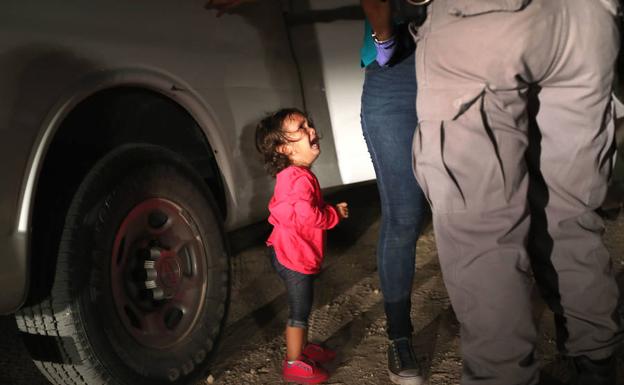 Una niña hondureña llora al ser detenida su madre en la frontera entre EE UU y México.
