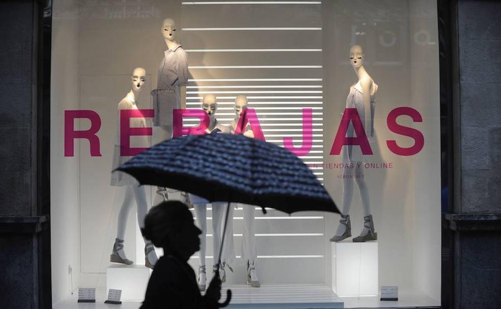 Una mujer pasa por delante de una tienda de moda.