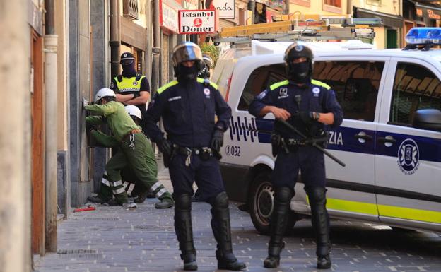 Agentes de la Policía Local de Vitoria protegen a los técnicos de Iberdrola que, hace un año, cortaron la luz del bloque ocupado de la calle Pintorería.