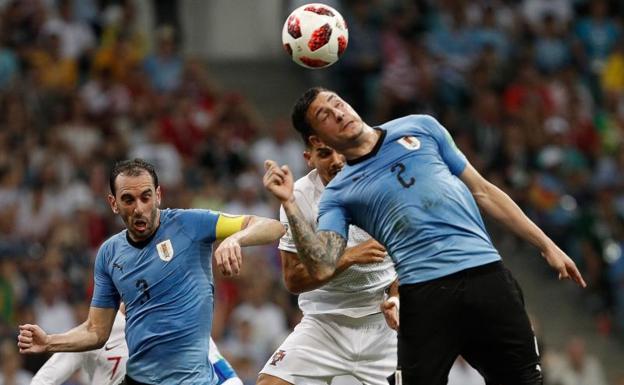 Giménez y Godín tratan de despejar el balón. 