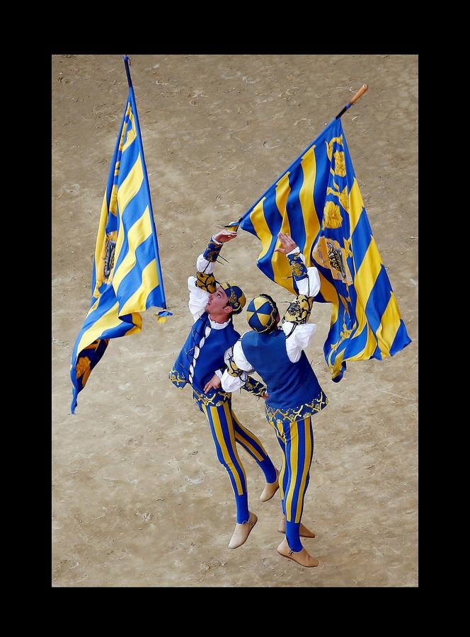 En la Piazza del Campo, en pleno corazón de Siena, en la Toscana, se celebra cada año, en dos ocasiones (las fotografías se tomaron el 2 de julio), la carrera de caballos de origen medieval conocida como «Il Palio.» La ciudad se engalana con estandartes, blasones y guirnaldas para celebrar tres días de alegría durante los cuales, además de participar en las bendiciones de los animales, es posible disfrutar de música y conciertos. En la carrera participan diez caballos, que representan a alguna de las «contradas» o distritos de la ciudad, y han de dar tres vueltas completas a la Piazza del Campo. El primero en terminarlas, con o sin jinete, será el ganador.