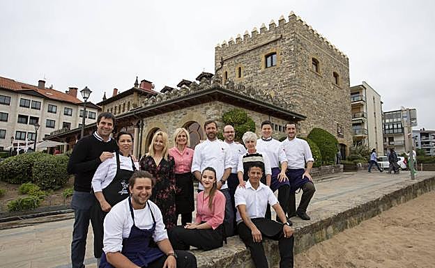 El equipo de cocina posa ante el hotel
