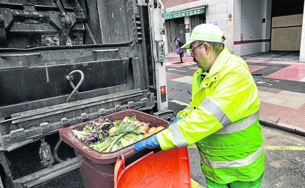 Un trabajador de la empresa Fomento de Construcciones y Contratas retira la basura depositada.