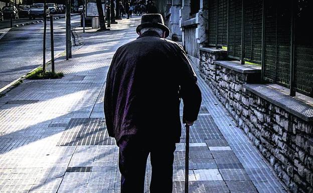 Un anciano camina solo. 