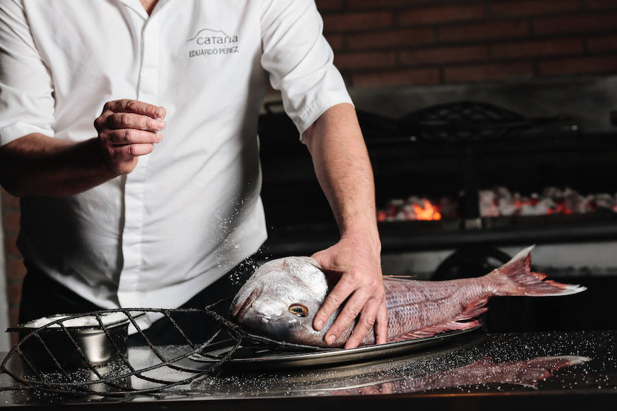 Eduardo Pérez sala un besugo en la parrilla del Cataria.
