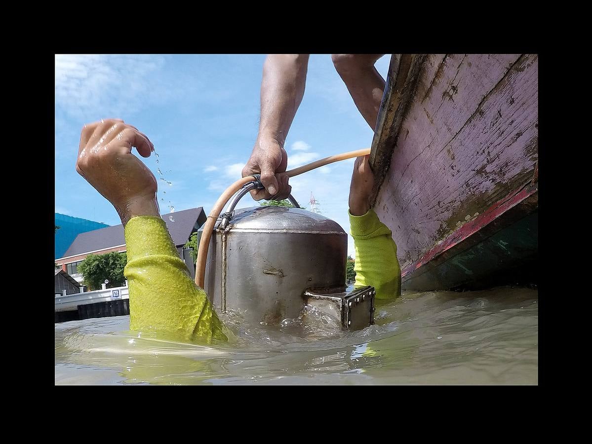 Hace unas semanas, equipos de buzos bien entrenados acapararon el interés mundial por el audaz rescate de 12 niños en una cueva anegada en Tailandia. Pero los buceadores de una pequeña comunidad de ese país, conocida como los «Indiana Jones,» se zambullen a diario hasta a 30 metros con un rudimentario casco de metal, que recuerda a una olla conectada a un tubo de goma, en el turbio cauce del río Chao Phraya, en Bangkok, en busca de tesoros. A veces, consiguen encontrar monedas, joyas o cerámica que pueden vender hasta por el doble del salario mínimo; otras, el hallazgo es macabro: cráneos y esqueletos sobre el lecho del río. Siempre a oscuras.