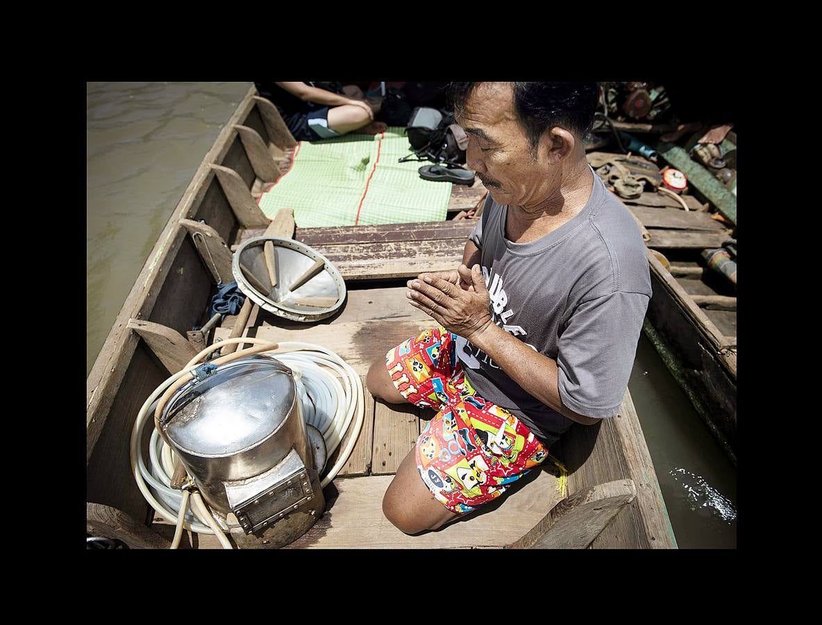 Hace unas semanas, equipos de buzos bien entrenados acapararon el interés mundial por el audaz rescate de 12 niños en una cueva anegada en Tailandia. Pero los buceadores de una pequeña comunidad de ese país, conocida como los «Indiana Jones,» se zambullen a diario hasta a 30 metros con un rudimentario casco de metal, que recuerda a una olla conectada a un tubo de goma, en el turbio cauce del río Chao Phraya, en Bangkok, en busca de tesoros. A veces, consiguen encontrar monedas, joyas o cerámica que pueden vender hasta por el doble del salario mínimo; otras, el hallazgo es macabro: cráneos y esqueletos sobre el lecho del río. Siempre a oscuras.
