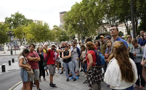 Un grupo de turistas escucha las explicaciones de un guía en Bilbao.