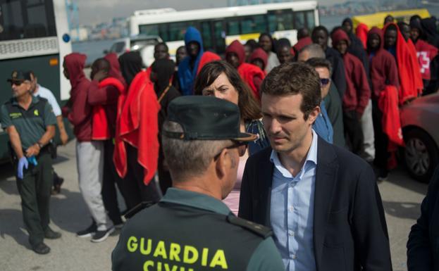 Casado conversa con un guardia civil durante una visita al puerto de Algeciras. 