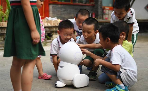Varios niños se acercan a un robot. 