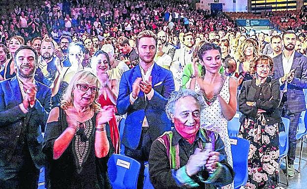 Imagen principal - Los invitados aplauden a uno de los premiados. Larrodera recoge el Mainat de manos de su hija. Fiestras junto a Emilio Aragón y su esposa.