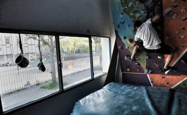 Un joven practica la escalada en un rocódromo. 