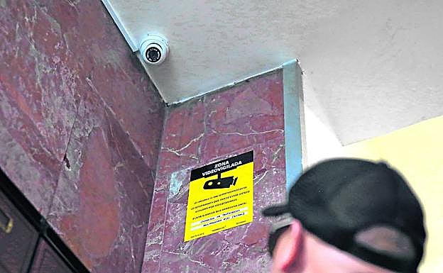 Anderson observa la cámara de vídeovigilancia instalada en su portal. 