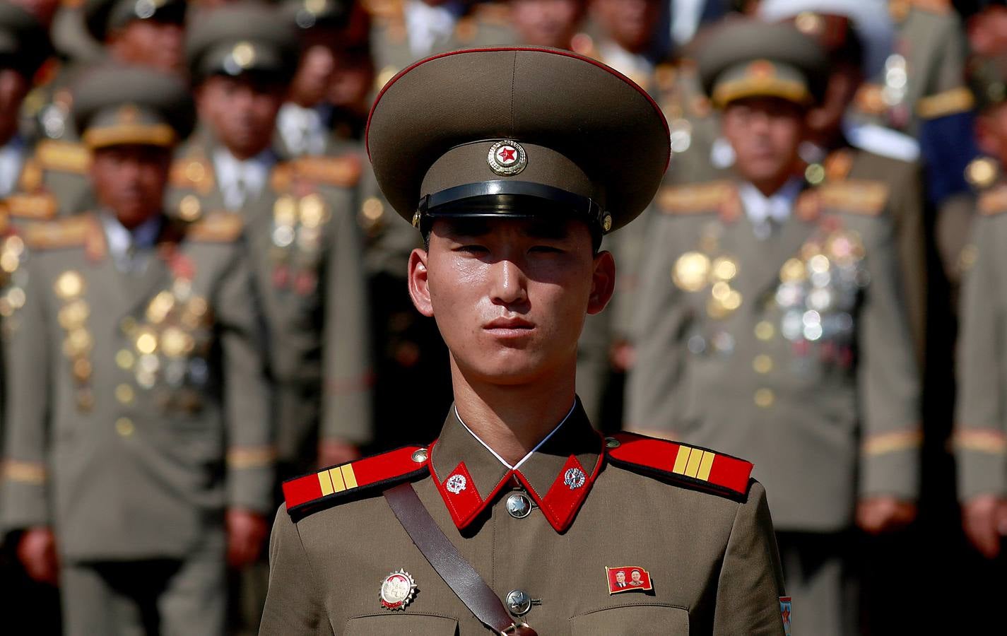 Un militar con la insignia de los dos líderes..