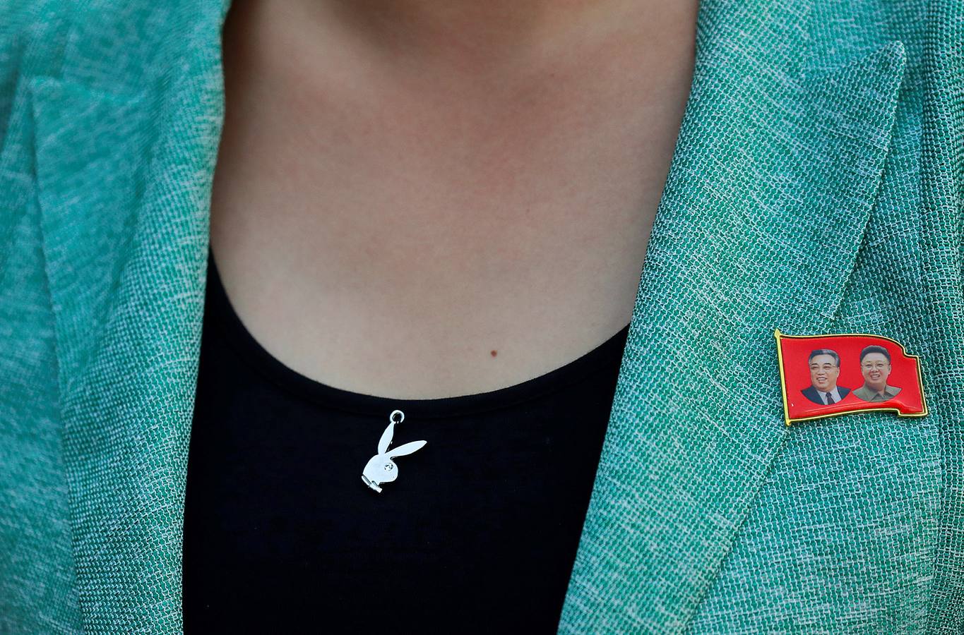 Una mujer con un pin de Kim Il Sung, fundador del país, y su hijo Kim Jong Il, el padre del actual líder Kim Jong Un.