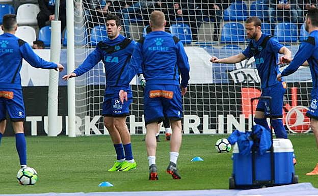 El equipo calienta sobre el césped de Mendizorroza. 