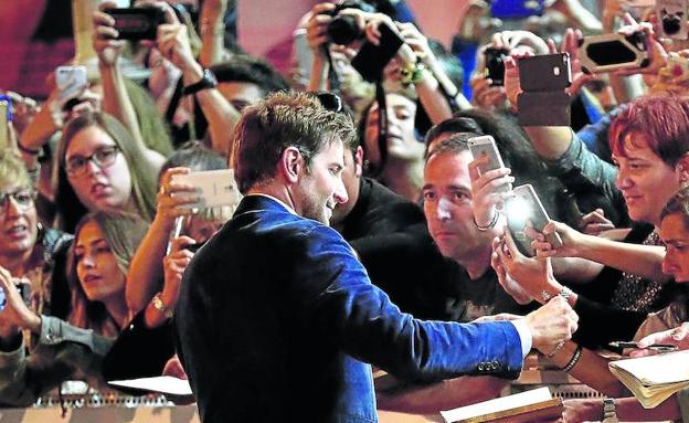 El actor estadounidense Bradley Cooper se hinchó a firmar autógrafos nada más llegar a San Sebastián, a la espera de que hoy presente su película 'A Star is Born'.