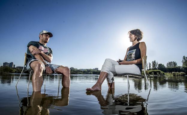 Ibai Gómez y Livia López dialogan con los pies metidos en el agua de los humedales de Salburua.
