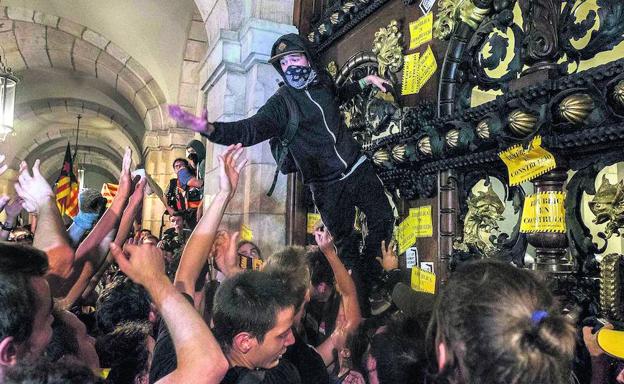 Tensión. Jóvenes radicales intentan asaltar el Parlament, en cuyo interior se tuvieron que atrincherar agentes de los Mossos mientras aguardaban a los refuerzos.