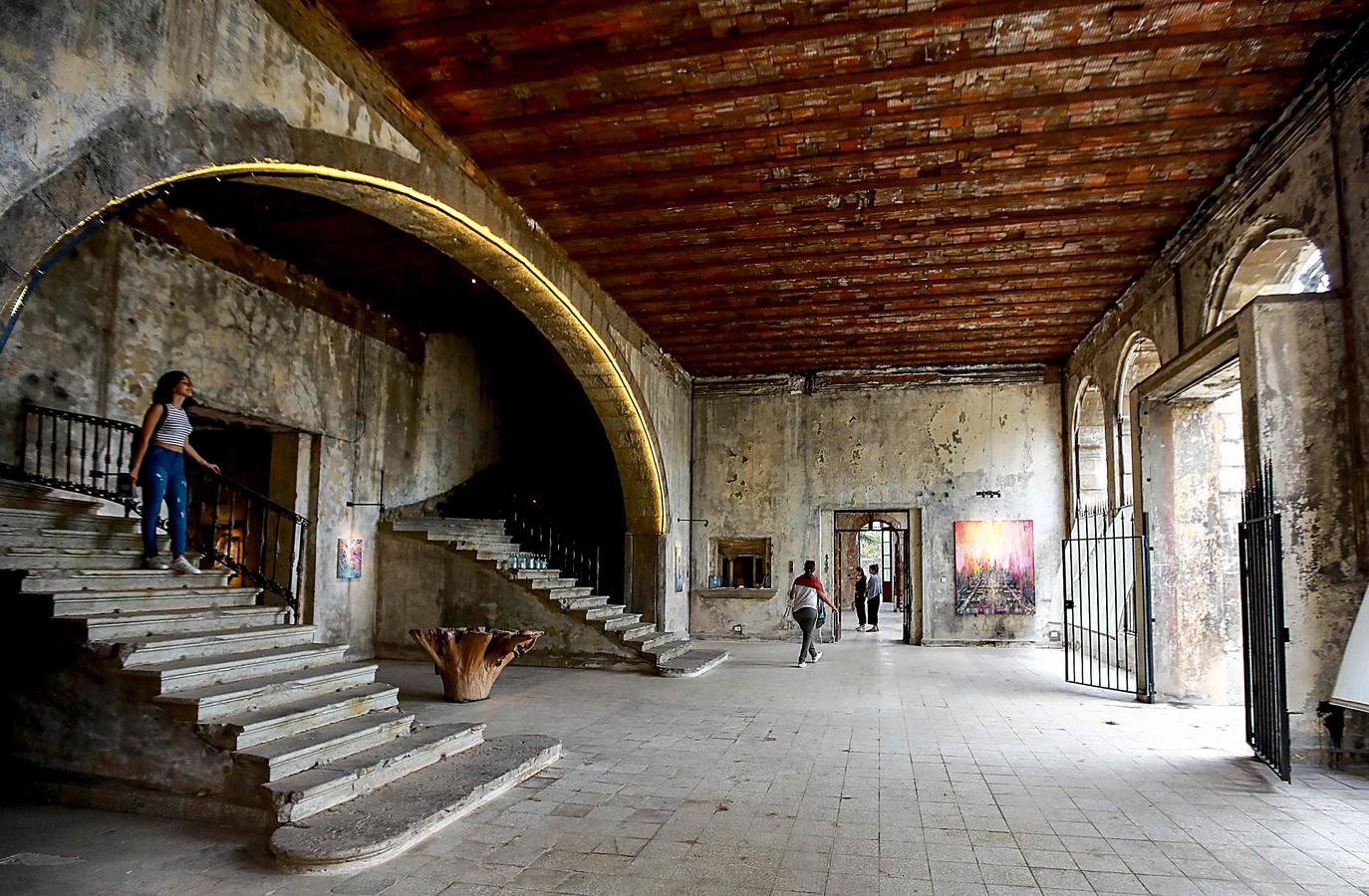 El Grand Hotel Casino Ain Sofar, construido en Líbano 1892 bajo el dominio otomano, fue el centro donde diplomáticos árabes, oficiales franceses y británicos junto a estrellas de cine egipcias se congregaron antes de que el conflicto de 1975-1990 lo obligara a cerrar. Ahora, bajo el cuidado de uno de sus dueños, esta maravilla arquitectónica está siendo restaurada como un lugar para el arte y ha abierto sus puertas para mostrar la obra del pintor británico Tom Young. El artista, afincado en el país desde hace diez años (con buzo azul delante de sus obras), reexamina los recuerdos, activa los espacios abandonados y se relaciona con el hotel y la huella de sus antiguos huéspedes y residentes.