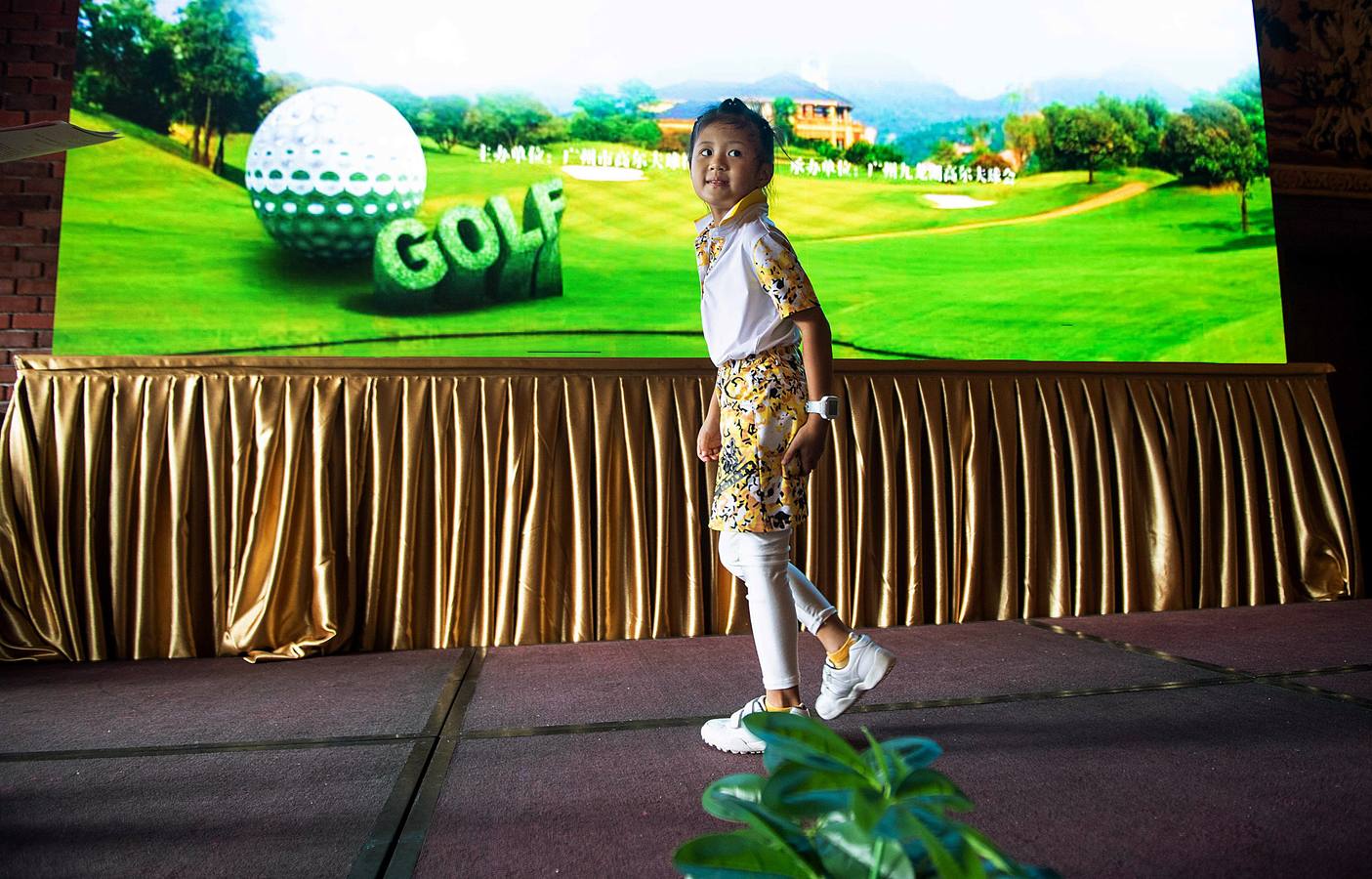 La Asociación China de Golf tenía 400 jugadores juveniles registrados en 2013, el año pasado eran 35.000 y se espera que en un lustro la cifra ronde los 100.000. Lai Runci, de 6 años, y Lai Yiyan, de 9 (protagonistas en la mayoría de las fotos), participan en un torneo para niños en Dragon Lake Golf Club en, Guangzhou. Ambos representan al ejército de jóvenes golfistas de China y el interés creciente del país por un juego que estuvo prohibido bajo el mandato de Mao Zedong porque era «para millonarios...»