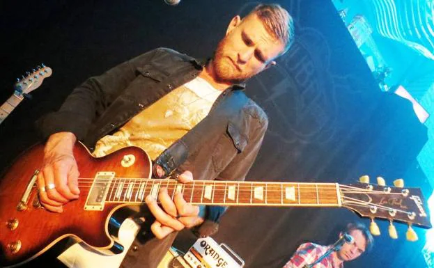 Ben Poole con camisa y guitarra Gibson Les Paul.