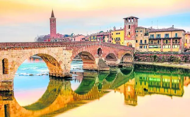 El puente de piedra, vestigio de la era romana, une el casco antiguo con las nuevos barrios. A la izquierda, la torre de la iglesia de Santa Anastasia.