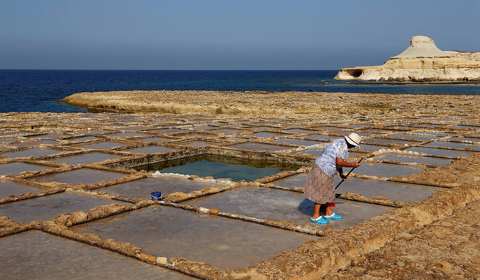 Zebbug, en la isla de Gozo, en Malta, es una pequeña localidad famosa por sus finos encajes; por los olivos, que le dieron el nombre, y por la sal. A ella se dedican numerosos habitantes que, como Josephine Xuereb y Rosa Cini (en las fotos), la tratan y almacenan en salinas excavadas en roca y en paneles de evaporación, que se extienden a lo largo de la costa, de la misma forma que hicieron otras generaciones desde hace más de 350 años. 