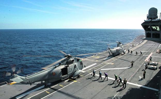 Imagen principal - Arriba, los 'Rainbow Warriors' asisten a dos helicópteros que acaban de aterrizar. Después, la dotación realiza labores para el desatraque del buque y, sobre estas líneas, la sala de máquinas.