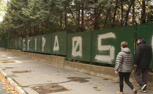Dos peatones pasan junto a uno de los grafitis más grandes de 'gripaos' que hay en Vitoria.