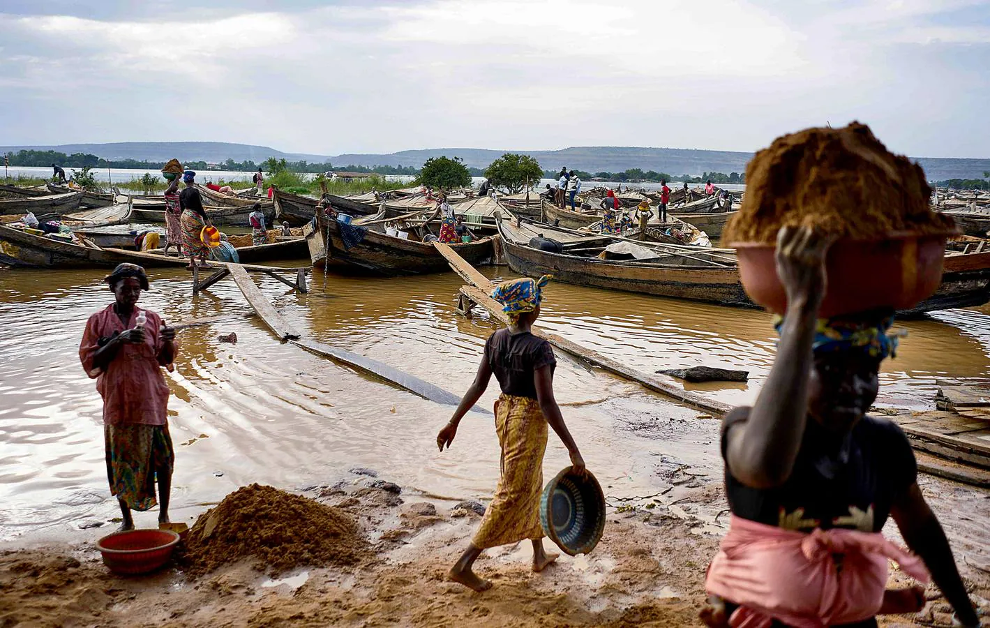 El auge de la construcción en Bamako, la capital de Mali, ha generado un espectacular aumento de la demanda de ladrillos fabricados con arena de alta calidad excavada a mano desde el lecho del río Níger. A esta ardua y peligrosa actividad se dedican decenas de personas, que acuden al lugar de extracción desde cientos de kilómetros y arriesgan sus vidas por alrededor de seis euros al día. Las corrientes y tormentas ponen muy a menudo en peligro sus frágiles embarcaciones