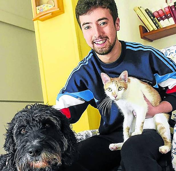 Lander, en casa, con el perro Pluto y el gato Bowie.