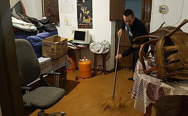 Un vecino de Bobadilla Estación trata de achicar agua en su vivienda. 