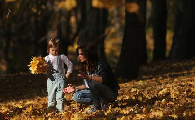 Una madre juega con su hija en un parque.