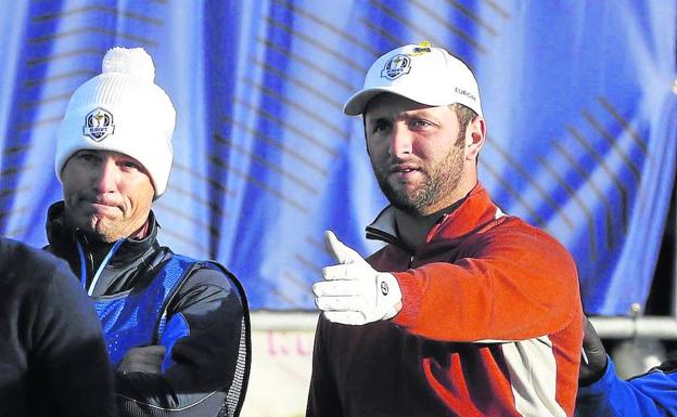 Rahm indica una trayectoria a su caddie, Adam Hayes, durante la pasada Ryder Cup.