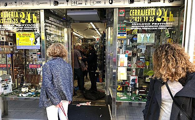 El trabajador agredido habla con un agente en el interior del local.