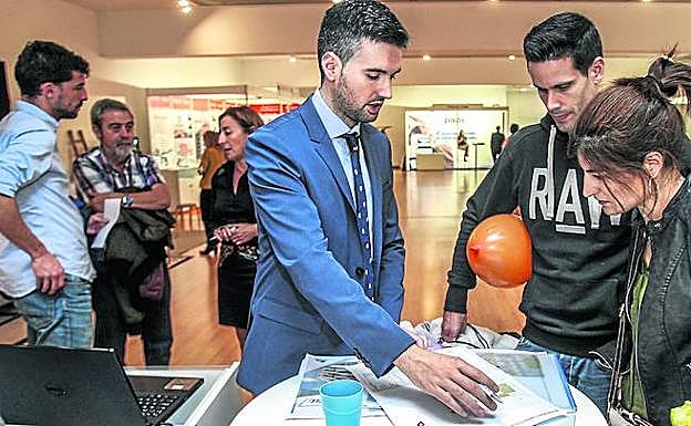 Una familia realiza una consulta en uno de los puestos del Salón Inmobiliario de Álava. 