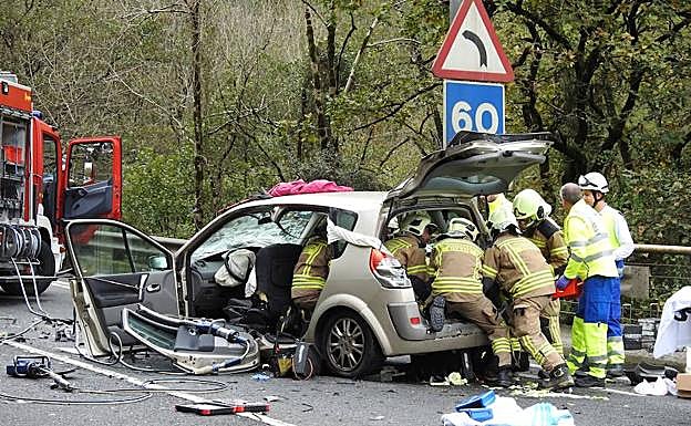 Los bomberos rescatan a uno de los ocupantes del vehículo. 