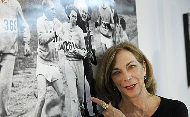 Kathrine Switzer, junto a la foto en la maratón de Boston por la que ha pasado a la historia.