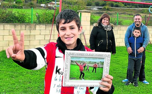 Gari, con el artículo que este periódico le dedicó. Detrás, sus padres y hermano, Telmo.