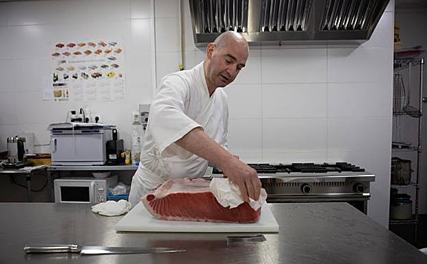 Jiménez mima una pieza de pescado en su cocina.
