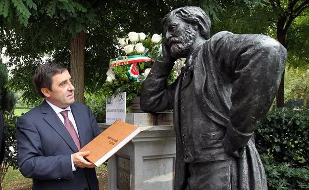 Juan Carlos Matellanes con el libro de cartas de Verdi ante su estatua en Bilbao. 