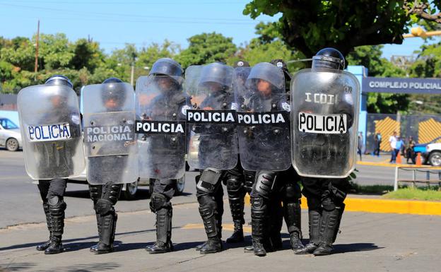 Oficiales de la policía antidisturbios montan guardia frente a la sede de la policía en Managua, Nicaragua.