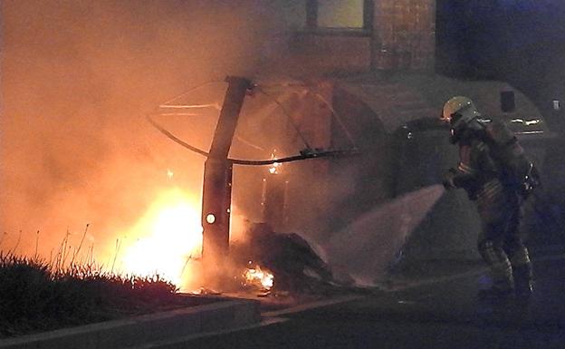 Los bomberos sofocan el fuego del contenedor. 